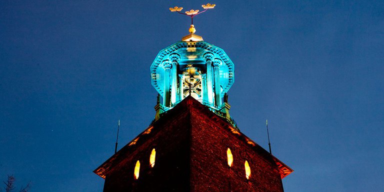 Koppartaket på Stockholms stadshus torn, mot mörkblå kvällshimmel. Designat av arkitekten Ragnar Östberg är Stadshuset ett av Stockholms mest karaktäristiska landmärken.