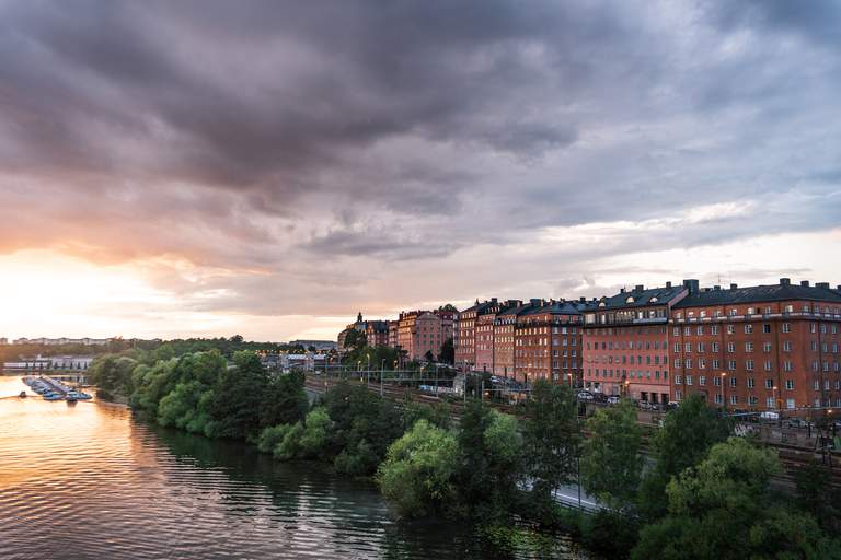 Solnedgång över vatten och orangea hus i centrala Stockholm