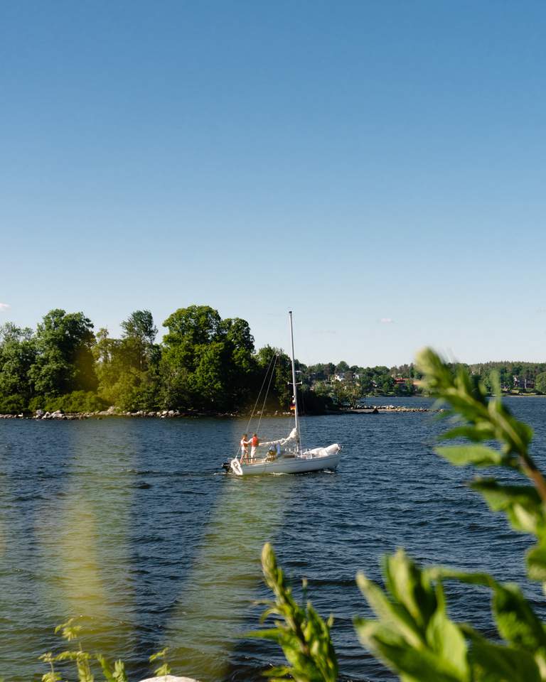 Stockholms skärgård. Sommar. En segelbåt färdas på vattnet utanför Fjäderholmarna.