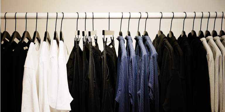 Svarta, vita och blå skjortor och byxor hänger i Hopes flaggskeppsbutik i Stockholm. För att bryta könsstereotyper har det svenska märket sedan 2016 designat alla sina kläder i en unisex standard.