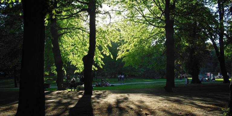 The Humlegården park on a sunny spring day. People are relaxing in the grass and walking along the park’s walkways. Located centrally, in Östermalm, Humlegården is one of Stockholm’s most popular parks.