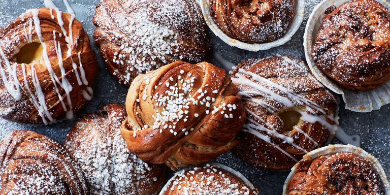 En bild av klassiska svenska kanelbullar. De nybakade bullarna är bruna med pärlsocker på. Kanelbullen är älskad av svenskarna och det populäraste fikabrödet med bred marginal.