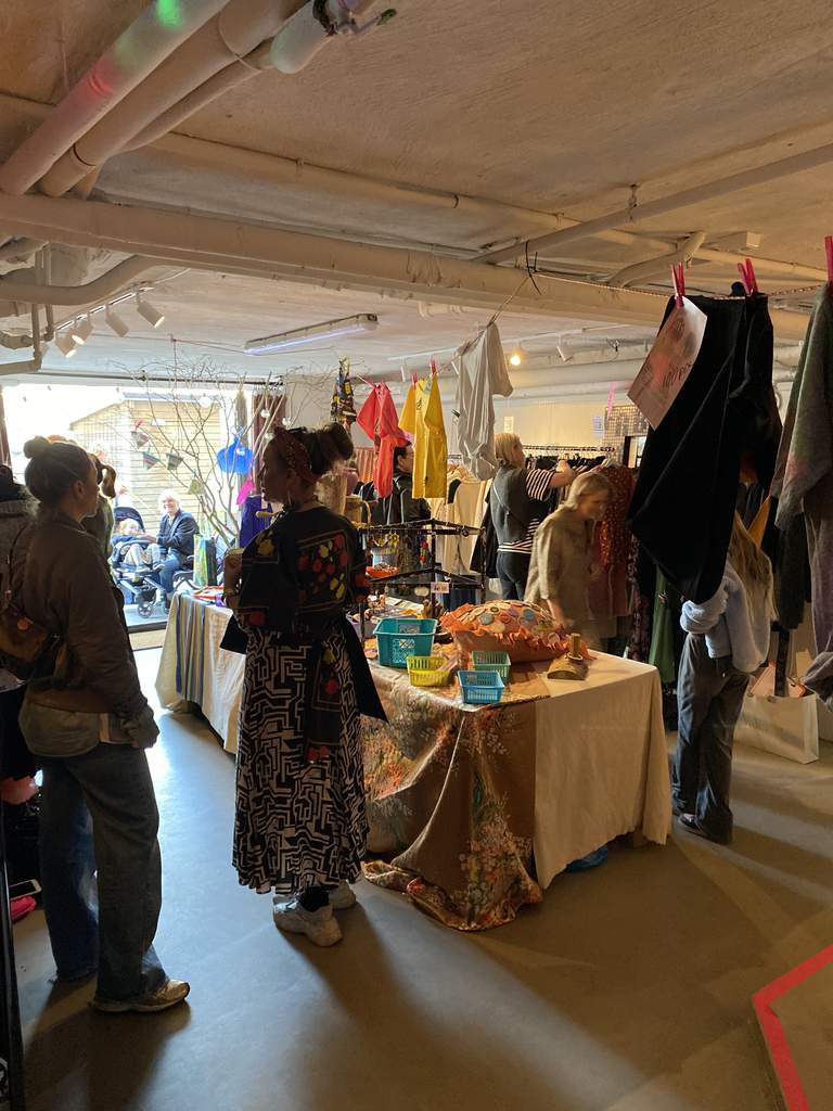 Vintage och second hand kläder och föremål och kunder i en butik.