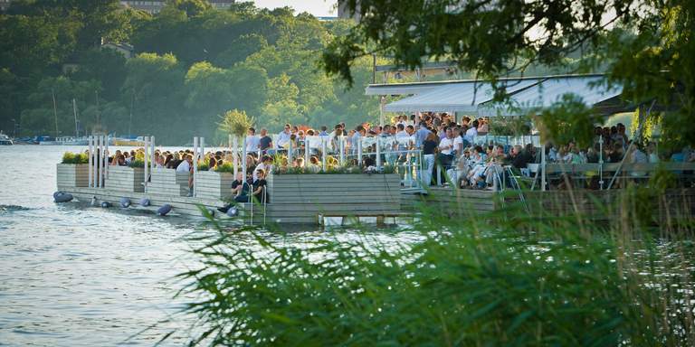 A view over the jetty and outdoor restaurant Mälarpaviljongen at Norr Mälarstrand in Stockholm. The restaurant is located both on land and out on the water.