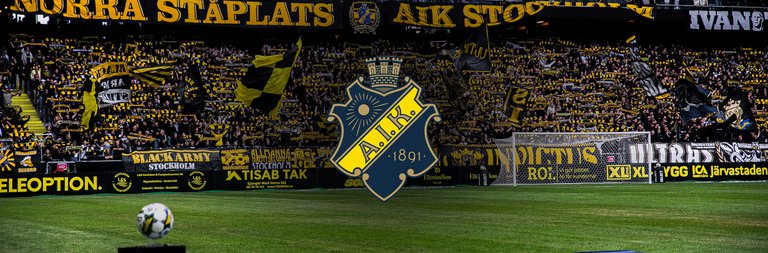 Fotbollsplan och AIK-loggan.