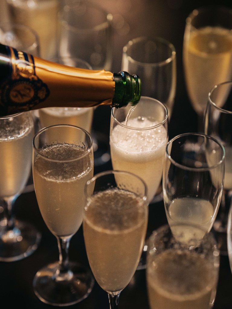 Champagne som hälls från en flaska i champagneglasen.