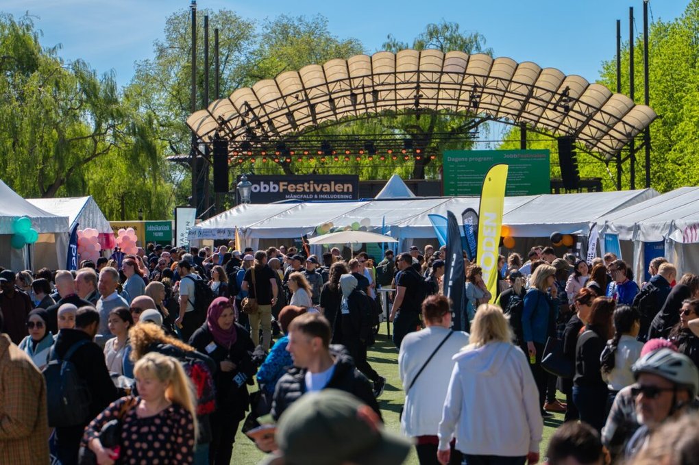 En folksamling framför festivaltält i Kungsträdgården.