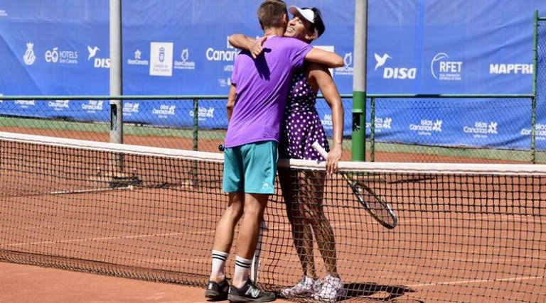 Två tennisspelare som kramas på en tennisplan