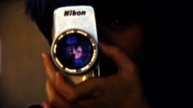 En hand som håller en Nikon-kamera.