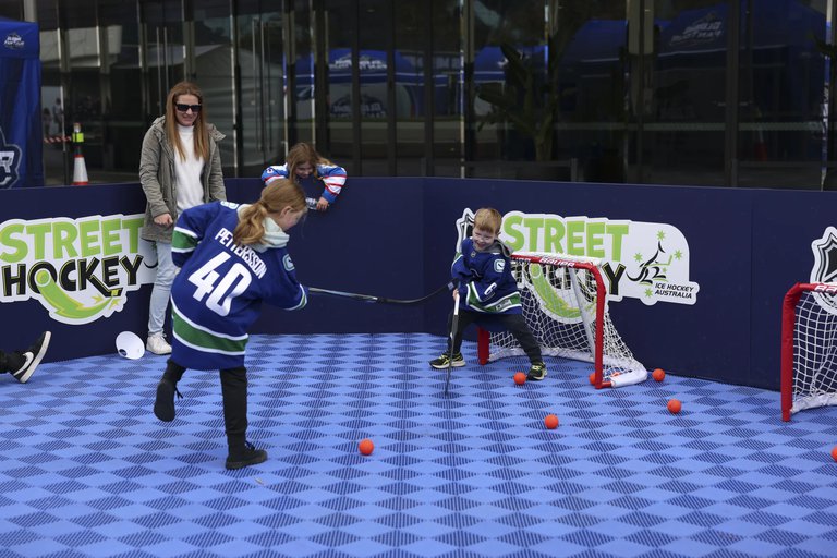 Två barn som tränar street hockey