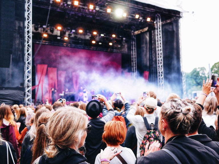 Ett publikhav framför en stor scen full med rök och färggladd ljussättning