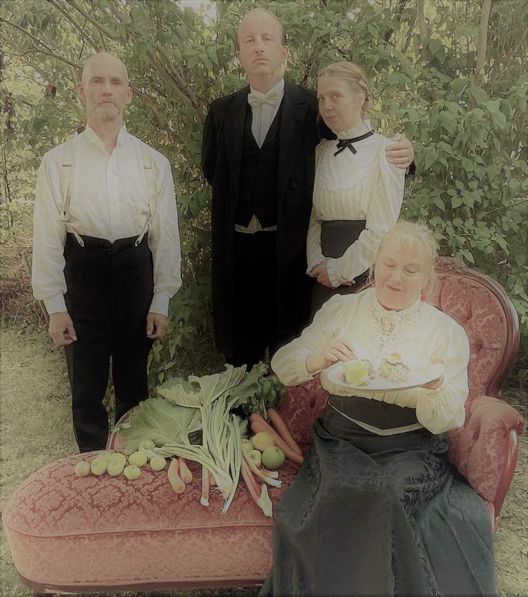 En kvinna som sitter på en soffa med frukt och grönsaker och tre personer som står bakom henne i en trädgård.