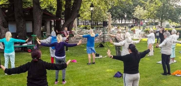 Människor som tränar Qi Gong i en park.