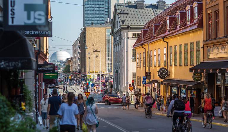 En livlig stadsgata med fotgängare och cyklister.