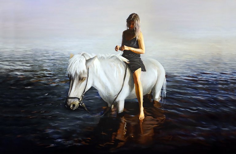 En person som sitter på en häst som står i vattnet.