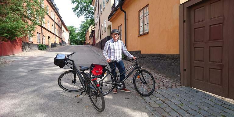 En person med två cyklar på en stadsgata.