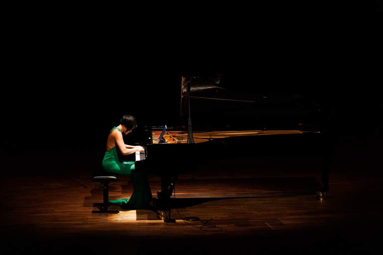 Musik i Stockholm. Pianisten Yuja Wang sitter framför en flygel, under en konsert på Konserthuset i Stockholm.