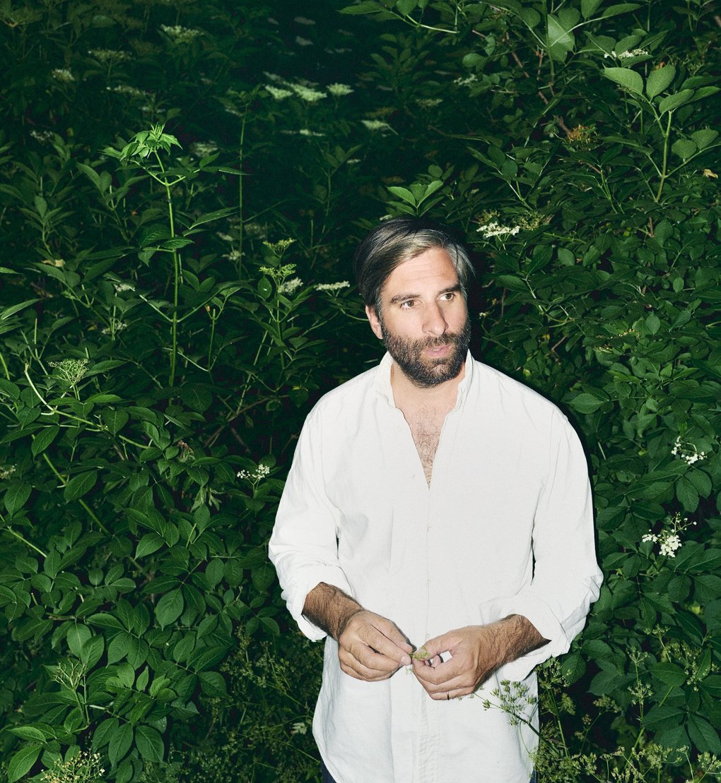 Adam Olenius omgiven av gröna växter.