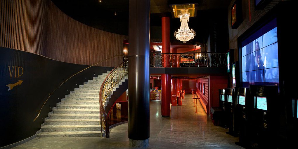 The lobby at Rigoletto, a movie theater in Stockholm. A chandelier is hanging from the ceiling at the classic theater, with one of the biggest screens in Sweden.