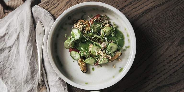 Vegetariska restauranger i Stockholm. En tallrik med vegetarisk mat. Grönsaker, örter och en lättare dressing.