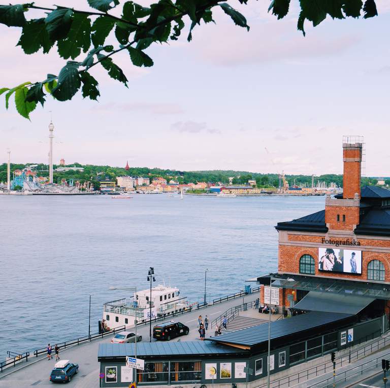 Museet Fotografiska huserar i ett stort tegelhus vid vattnet i centrala Stockholm med utsikt över Gamla Stan, Skeppsholmen och Djurgården