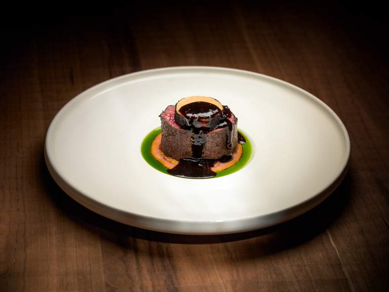 Restauranger i Stockholm. Bild på maträtt på Frantzén, Stockholms första restaurang med tre Michelin-stjärnor. En bit kött, toppat med en mörk sås.