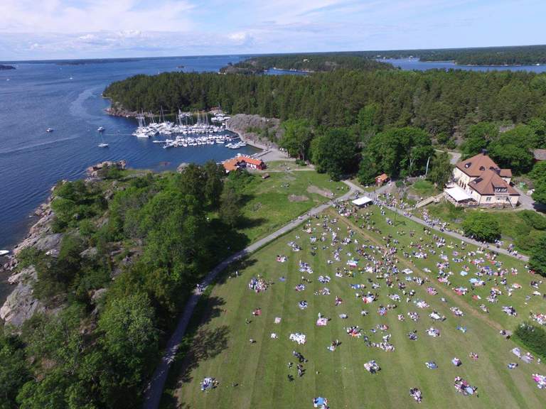 Utsikt över människor på en grön ö som har picknick.