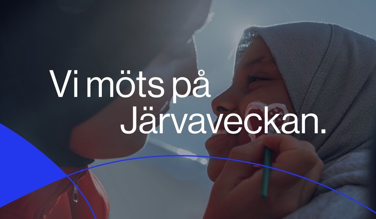 Närbild på ett barn i hijab som får hjärtan målade på kinden medan någon lutar sig nära. Över bilden står texten ”Vi möts på Järvaveckan.” Bilden förmedlar närhet, gemenskap och en välkomnande festivalstämning.