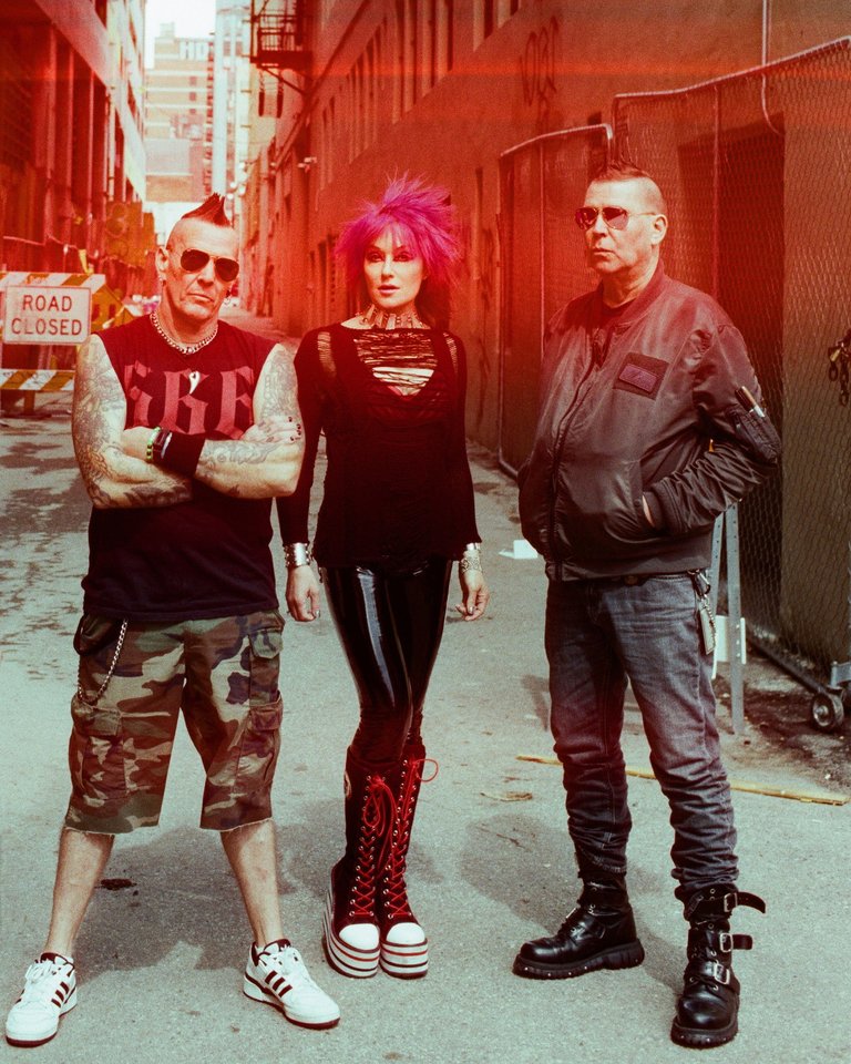 Medlemmarna i KMFDM står i en förfallen gränd.