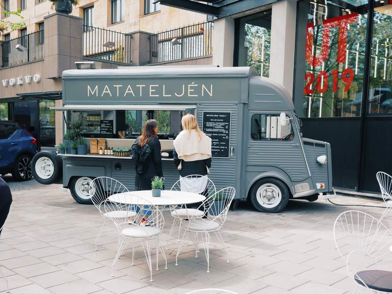 Food trucks i Stockholm. Två unga kvinnor står framför en food truck i centrala Stockholm, redo at beställa.
