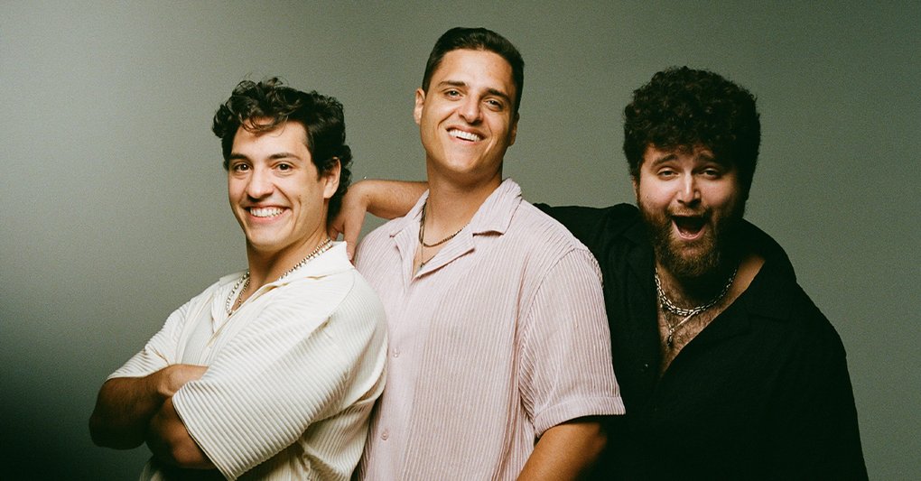 De tre medlemmerna av OCT ler mot kameran