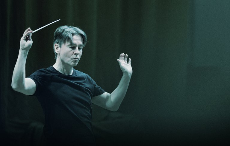 Dirigent Esa-Pekka Salonen dirigerar mot en mörkgrön bakgrund
