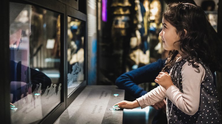 Museer i Stockholm. Ett barn trycker på en knapp vid en monter på Scenkonstmuseet.