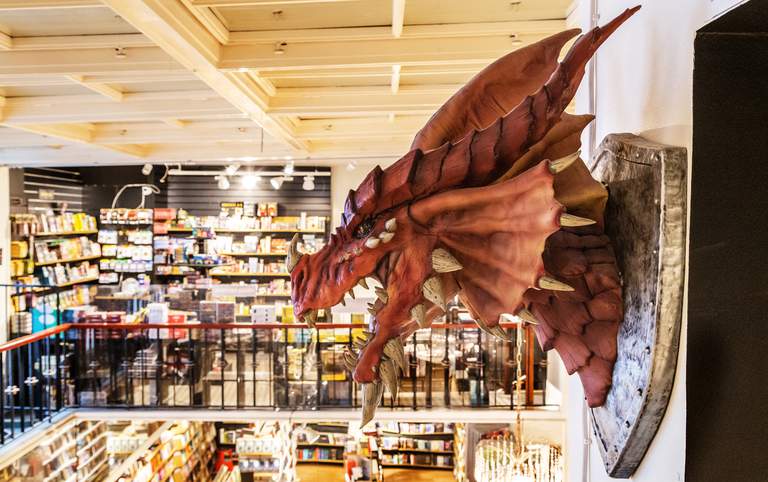 Shopping i Stockholm. Ett drakhuvud hänger på Science Fiction Bokhandeln.