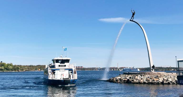 Sommar i Stockholms skärgård. En passagerarfärja anländer till Nacka Strand. På bilden syns även Carl Milles staty som hälsar passagerare välkomna.