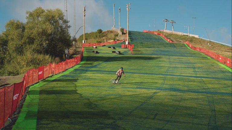 En skidåkare på en grön sluttning.