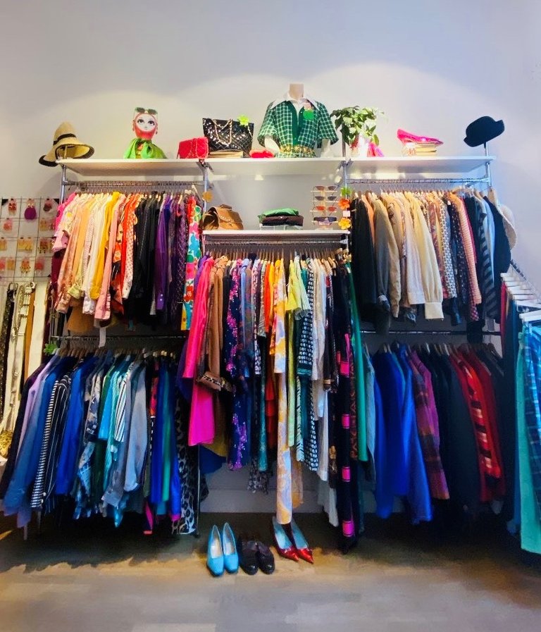 Second hand-butiker i Stockholm. Färggranna kläder hänger i Slow Fashion Hubs butik på Hornsgatan.