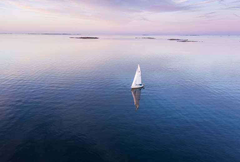 Stockholms skärgård. En segelbåt färdas på öppet vatten.