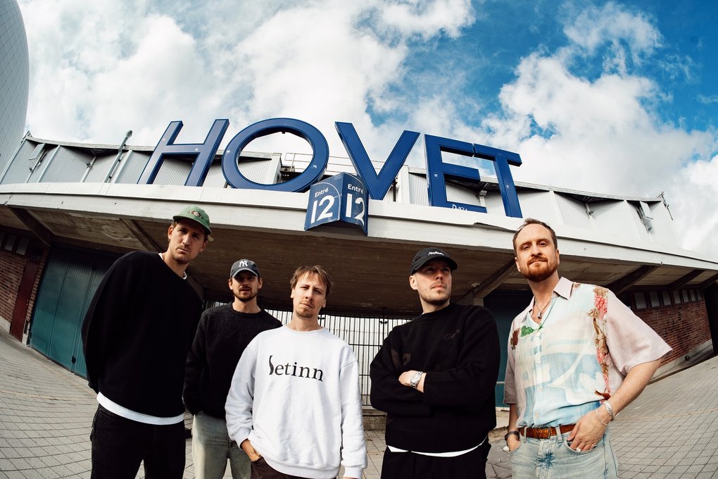 Fiskögeperspektiv på fem män som står utanför en hockeyarena.