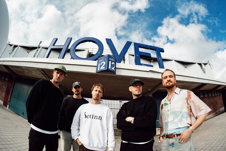 Fiskögeperspektiv på fem män som står utanför en hockeyarena.